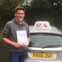 Dafi Griffiths – Jim #3 200 Dafi Griffiths smiling whilst holding his practical driving test pass certificate next to the JSF Driving School car