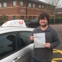 Liam Jurgens – Jim #3 200 Liam Jurgens proudly holding his practical test pass certificate standing beside the JSF Driving School car
