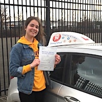 Martha Beard – Jim #3 200 Martha Beard smiling whilst holding her practical test pass certificate next to the JSF Driving School car