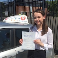 Billie Thomas – Jim Billie Thomas smiling and holding her practical test certificate standing beside the JSF Driving School car