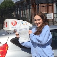 Anna Hallway Test Pass – Jim Anna Hallway smiling whilst holding her practical driving test pass certificate next to the JSF Driving School car.