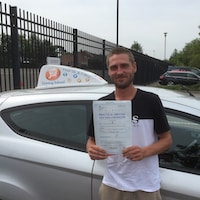 Delighted new driver holding he pass certificate after passing first time on a JSF Driving School intensive course