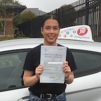 New driver Sian Gilbert standing next to the JSF School car smiling with her test pass certificate