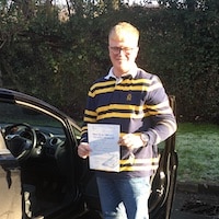 New JSF Driving School driver Hayden Edey smiling whilst holding his first time test pass at Monmouth Test Centre
